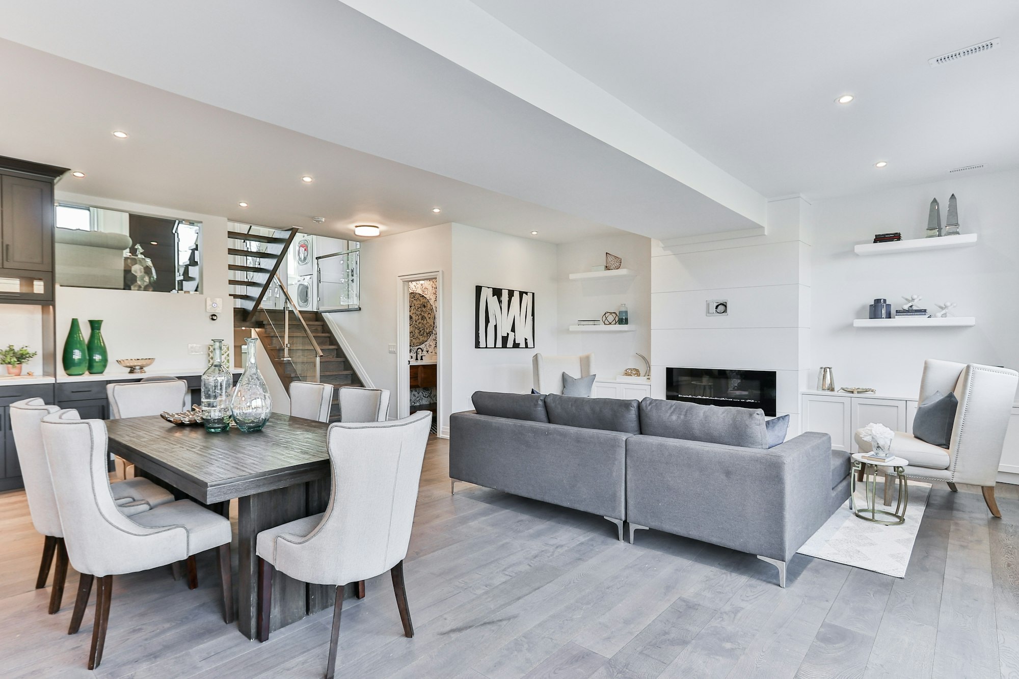 Open-plan main floor with dining table, sofa and fireplace