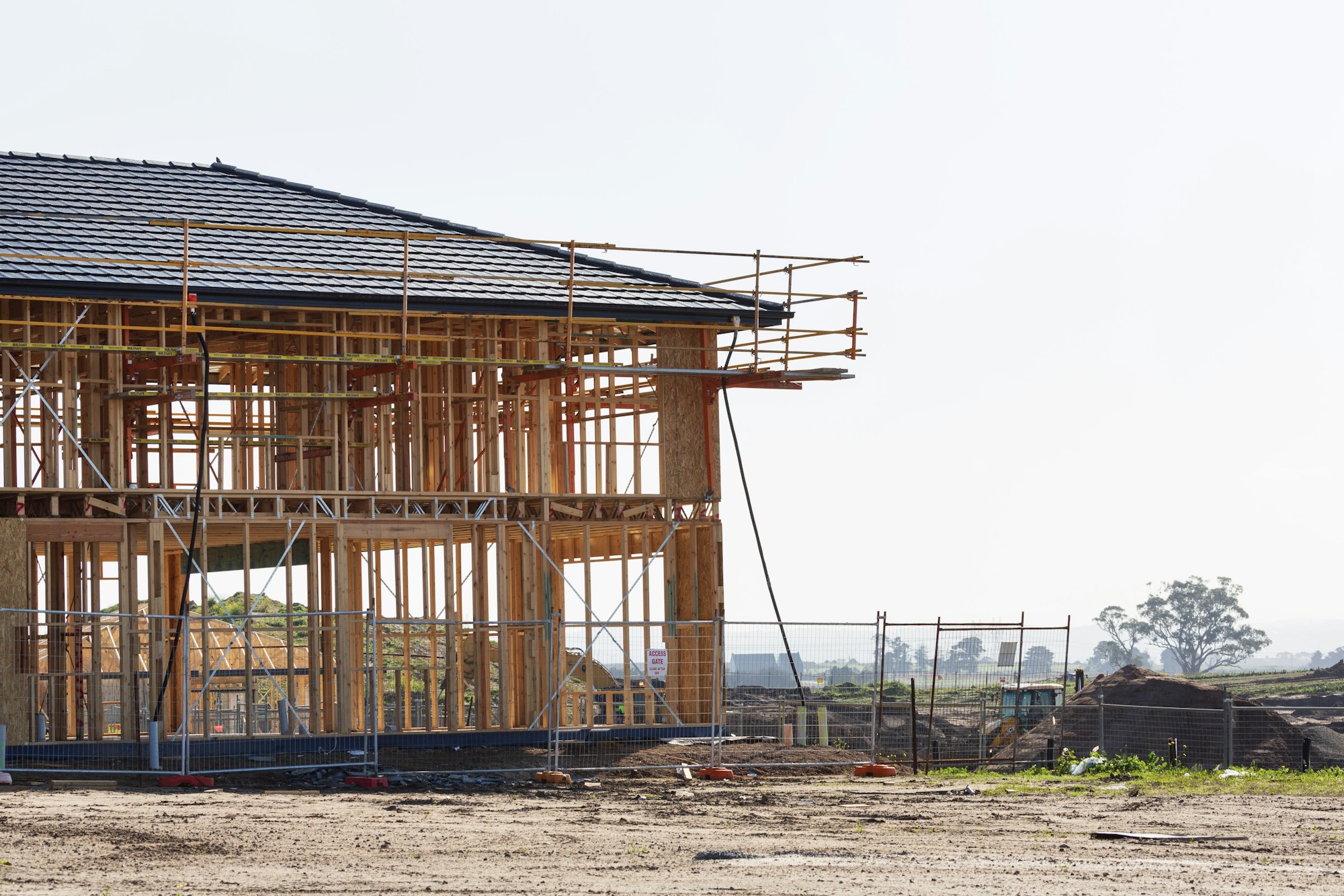 Wood frame of a two-storey building going up on a new foundation