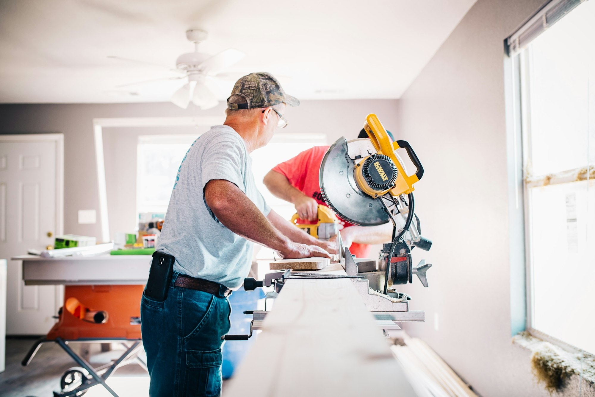 Carpenter cutting trim at a mitre saw